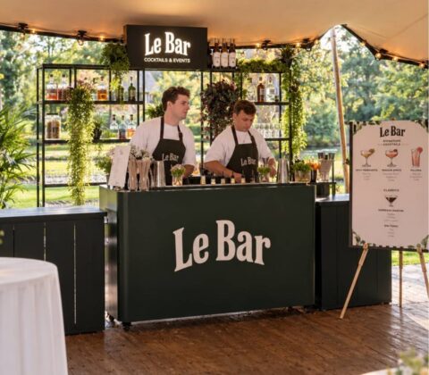 Twee bartenders van Le Bar werken achter de bar tijdens een besloten tentfeest