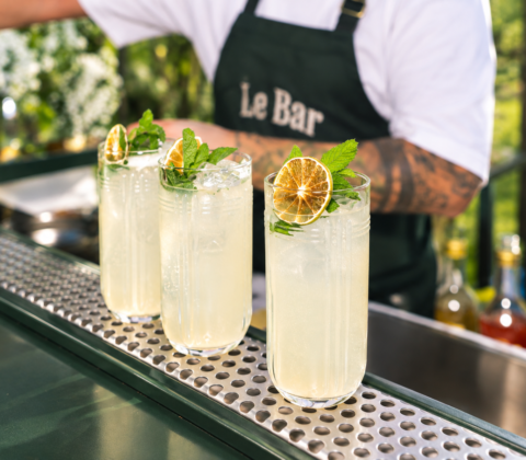 Bartender van Le Bar garneert drie glazen huisgemaakte limonade met munt en citroen