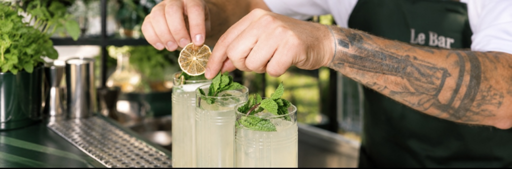 Bartender van Le Bar garneert huisgemaakte limonade met munt en gedroogde citroen